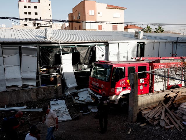 Feuerwehrfahrzeug vor eingestürztem Gebäude.