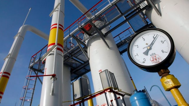 Druckmesser einer Gasleitung im Hintergrund Silos