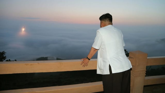 Kim Jong Un schaut von einem Balkon einem Raketenstart zu