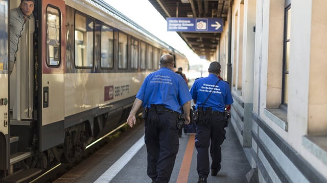 Zu sehen sind zwei Mitglieder der Grenzwacht in Uniform am Bahnhof in Chiasso