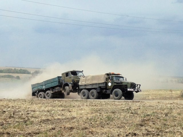 Ein Militärlastwagen schleppt einen zweiten ab