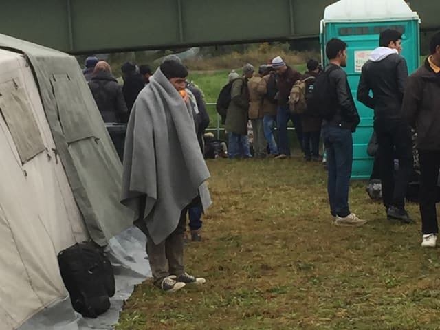 Männer stehen auf einem Feld herum.