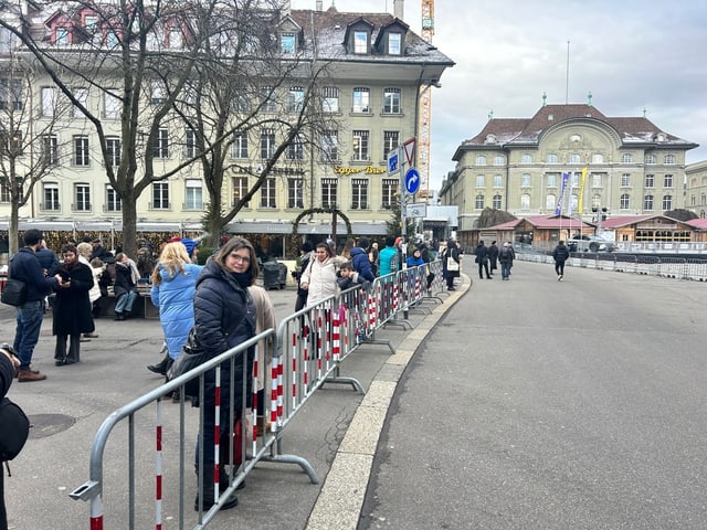 Zerstreut befinden sich einige Menschen hinter der Abschrankung am Bundesplatz.