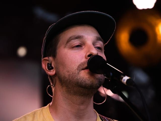 Der Sänger von The Cavers sing in das Mikrofon