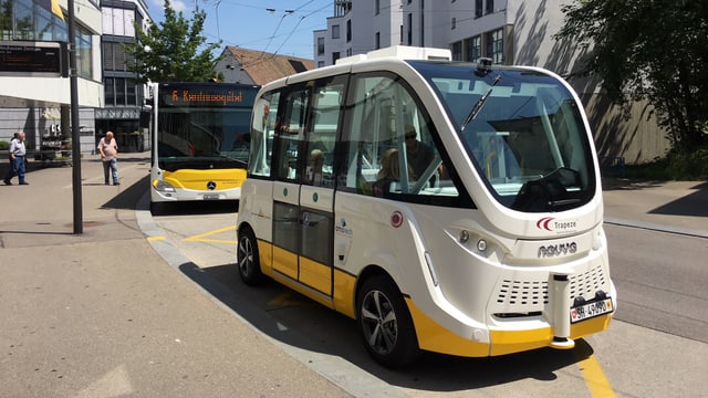 Futuristischer Minibus an einer Haltestelle in einer Stadt