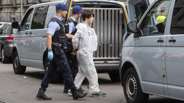 Klimaaktivist wird von zwei Polizisten vor der Credit Suisse abgeführt