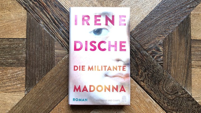 «Die militante Madonna» von Irene Dische liegt auf einem antiken Parkett.