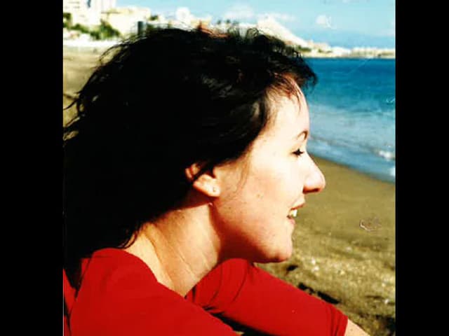 Christina Lang mit schwarzen Haaren am Strand. 