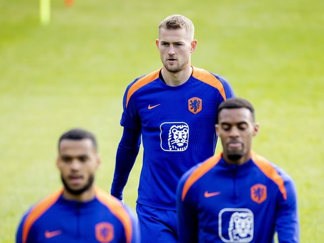 Fussballspieler in blauer Trainingskleidung auf dem Spielfeld.