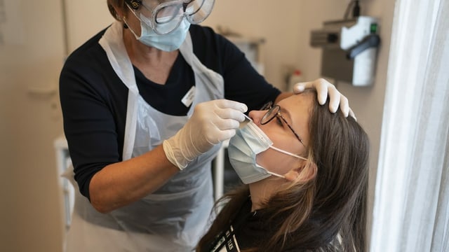 A teenage girl lets her doctor test her for Covid-19