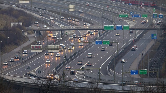 Viel befahrene Autobahn mit mehreren Fahrspuren bei Regenwetter.