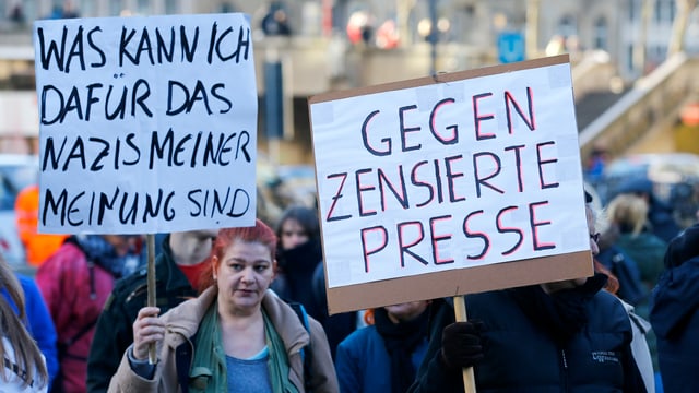 Demonstranten halten Plakate hoch 