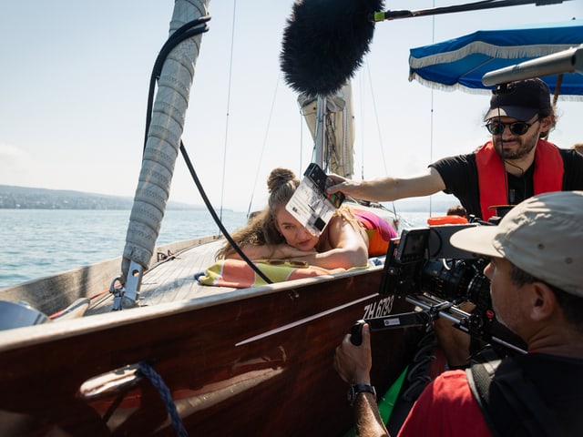 Crew filmt Szene auf einem Segelboot.