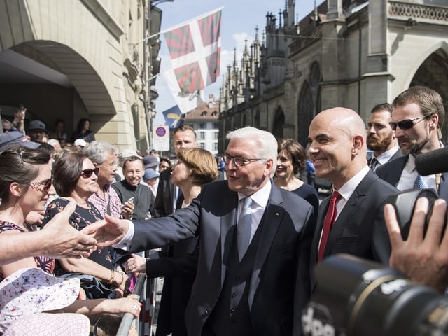 Frank-Walter Steinmeier und Alain Berset schütteln den Zuschauern auf dem Münsterplatz die Hände. 