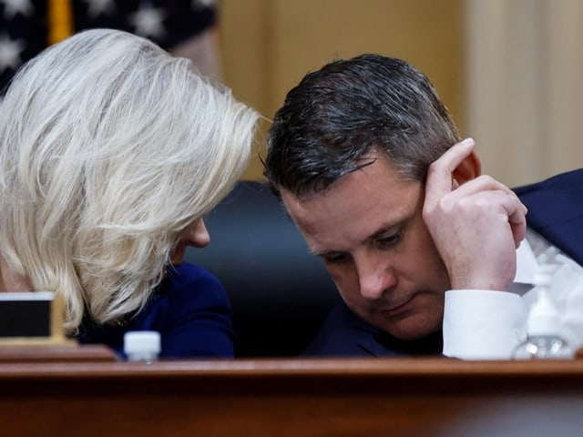 Cheney beugt sich zu Kinzinger, sie tuscheln