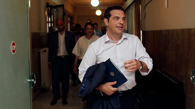 Tsipras in weissem Hemd, geht vorbei.