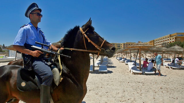 Polizist auf Pferd an Strand