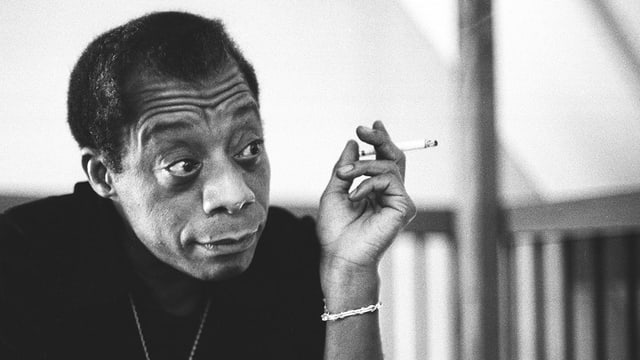 James Baldwin raucht eine Zigarette.