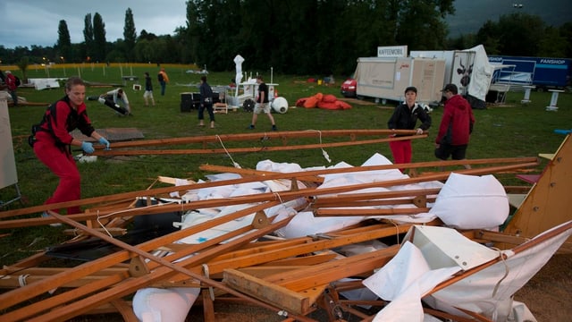 Helfer räumen die Überreste eines Festzeltes weg