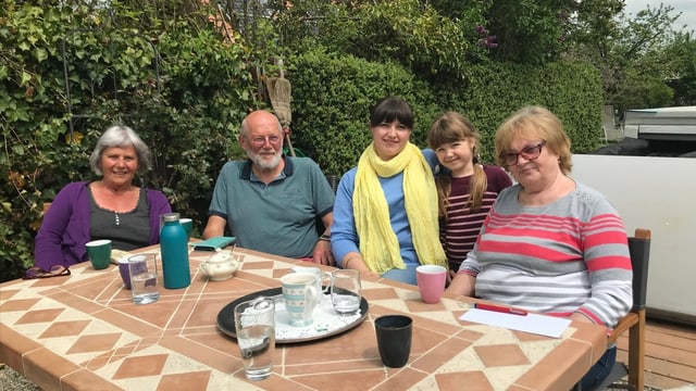 Gastfamilie und Geflüchtete an einem Tisch.