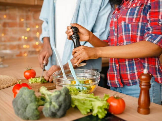 Ein Mann und eine Frau kochen Gemüse