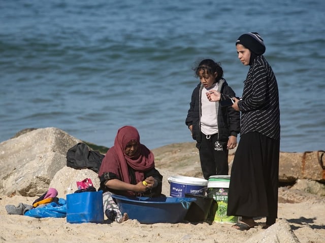 Eine Familie am Strand wäscht Kleider