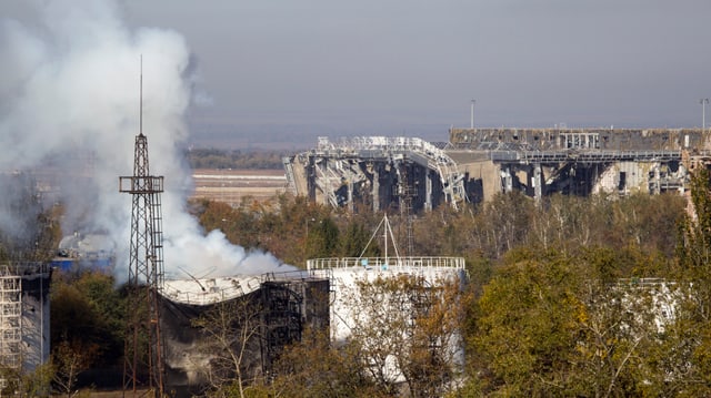 Rauch seigt auf aus den Trümmern der zerschossenen Abflughalle des Donezker Flughafens.