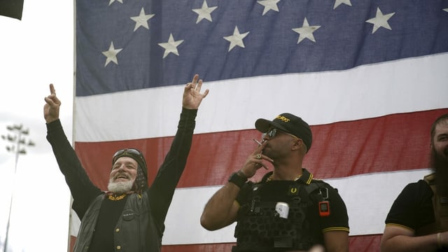 Men in front of American flag