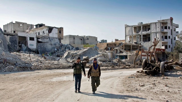 Kurdische Kämpfer gehen in Richtung Ortseingang von Kobane. 