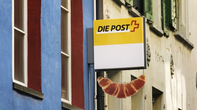 Schild der Post an Hausfassade