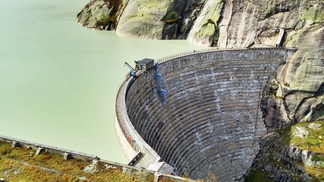 Staumauer mit Stausee, fotografiert von oben.