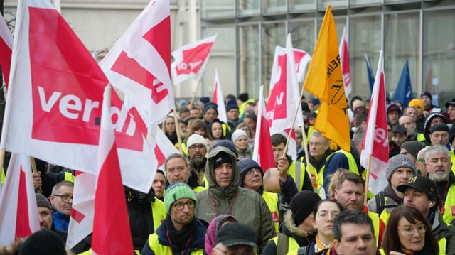 Menschenmenge mit roten verdi-Flaggen und gelben Warnwesten.