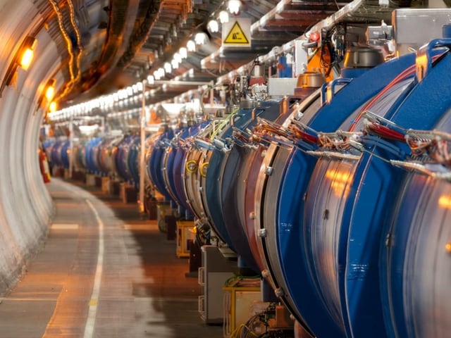 Ein Tunnel mit grossen blauen Maschinen und Kabeln.