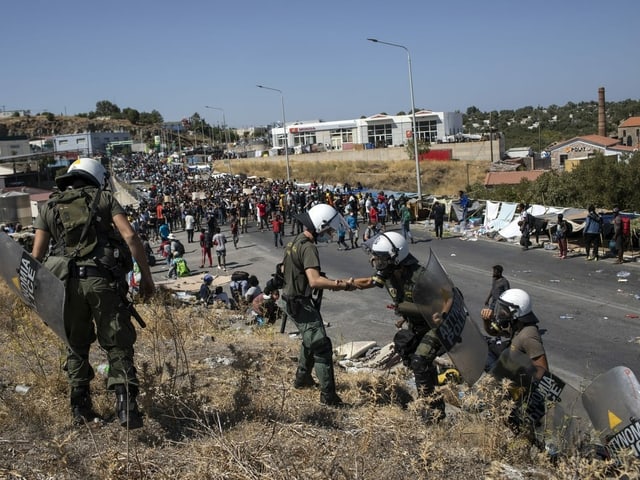 Police officers in front of protesters.