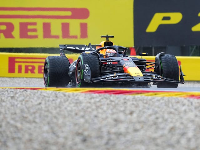 Formel-1-Auto auf einer Rennstrecke mit Pirelli-Werbungen im Hintergrund.