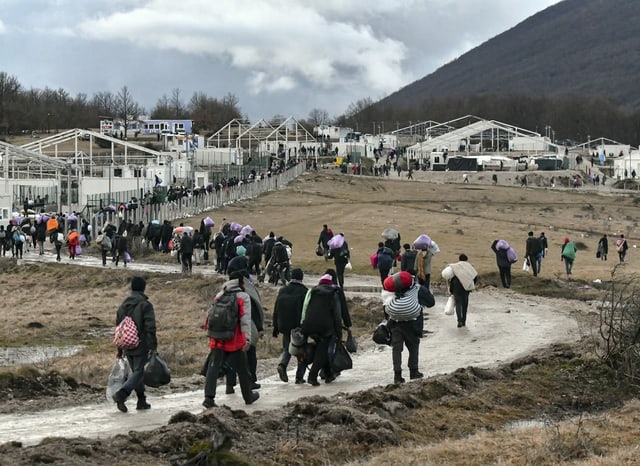 Migrants and refugees return to the burned camp