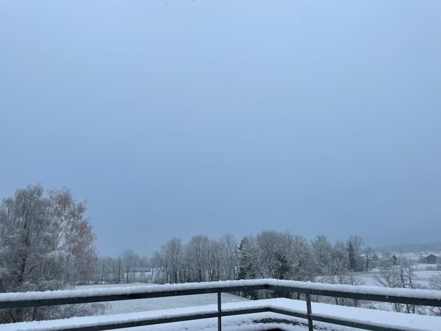 Wenige Zentimeter Schnee auf Balkongeländer.