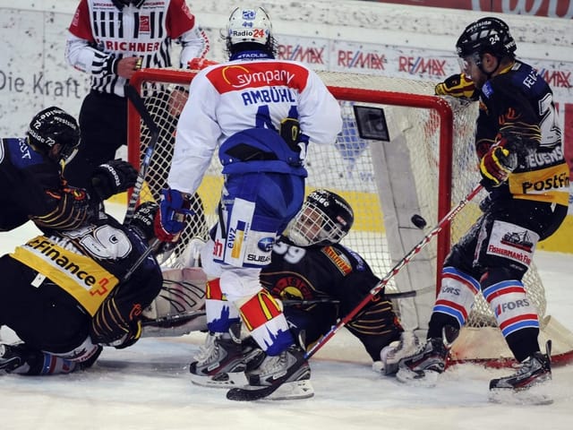 Eishockeyspieler kämpfen vor dem Tor um den Puck.