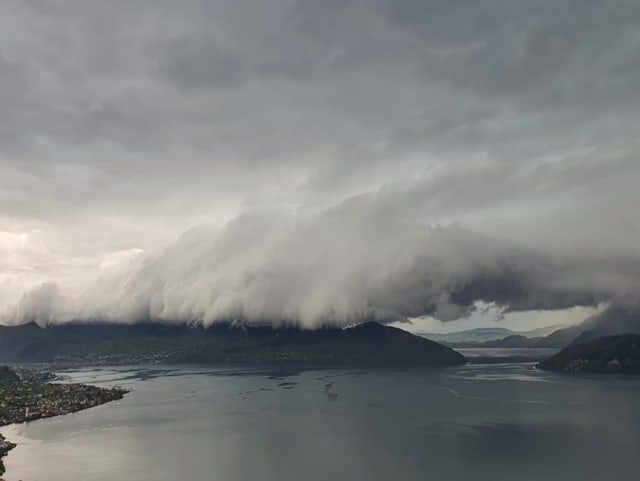 Tiefhängende Wolken über einem Berg.