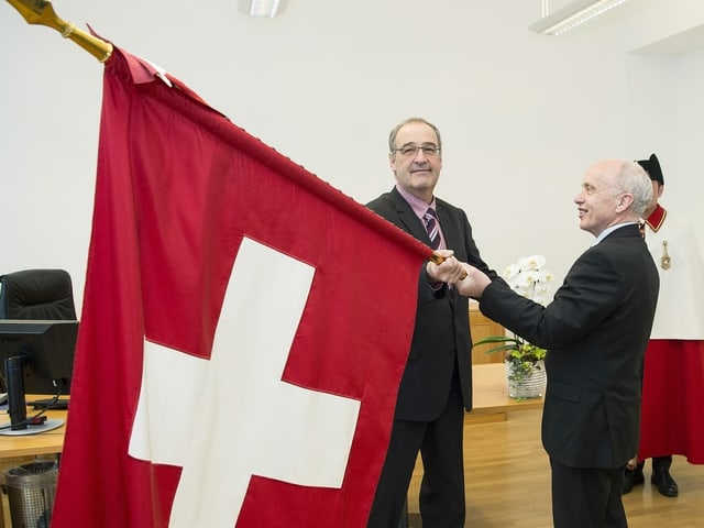 In December 2015, Ueli Maurer symbolically presented the Swiss flag to his successor as Defense and Sports Minister Guy Parmelin.