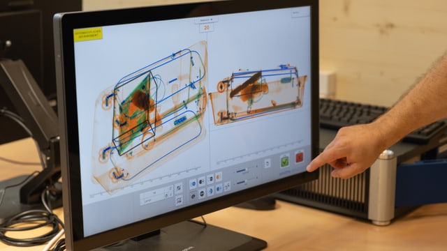 Ein Computerbildschirm, auf dem der Inhalt eines Handgepäcks dargestellt ist in verschiedenen Farben.