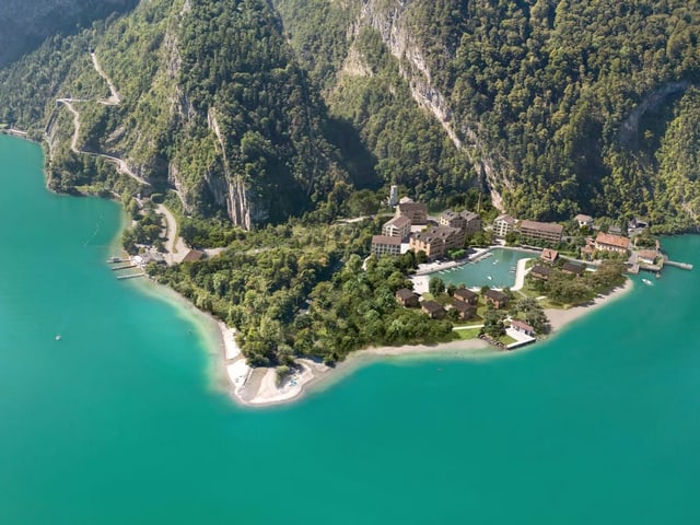 Eine grüne Halbinsel vor einem Berg.