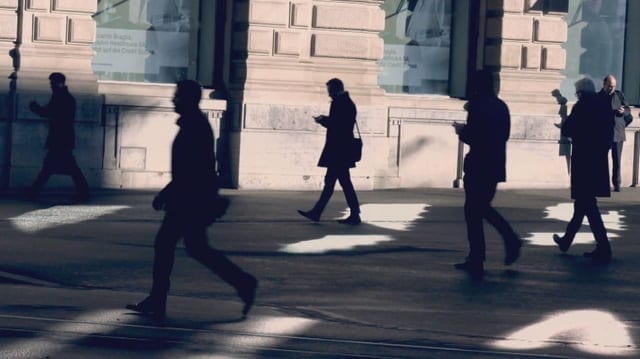 Menschen strömen am Gebäude der UBS vorüber.