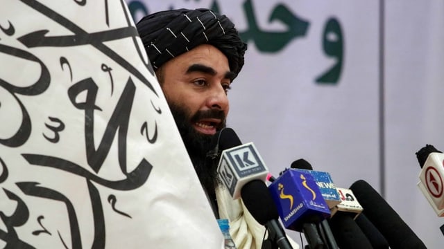 Zabiullah Mujahid spricht in Mikrofone.