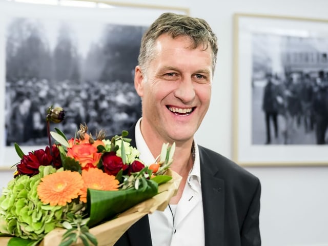 Thomas Stettler mit Blumen im Arm.