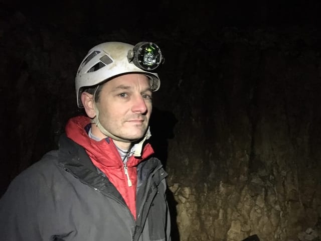 Mar Lütscher in der Höhle mit Helm und Stirnlampfe. 