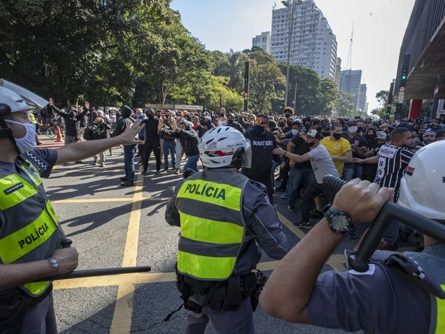 Polizisten halten Demonstranten auf Abstand. 