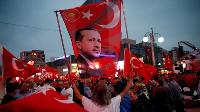 Demonstrant hält Türkei-Fahne mit Erdogan-Konterfei