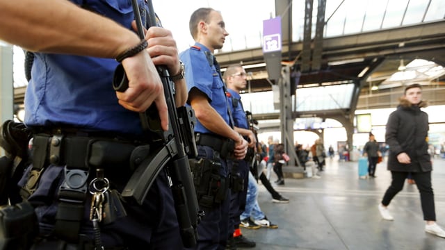 Schwer bewaffente Polizisten stehen in der Bahhhofhalle.