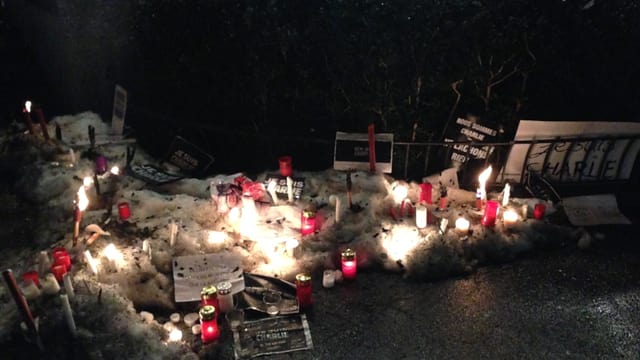 Kerzen im Schnee und Zettel mit der Aufschrift: Wir sind Charlie.